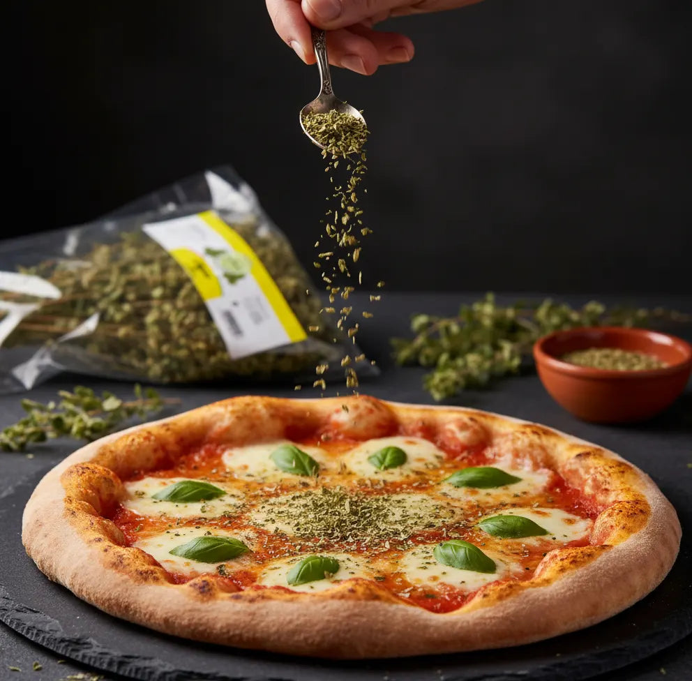 Person sprinkling herbs onto a pizza with a package of herbs in the background.