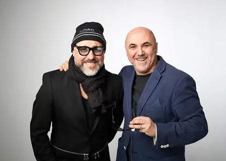 Two men posing together against a plain background